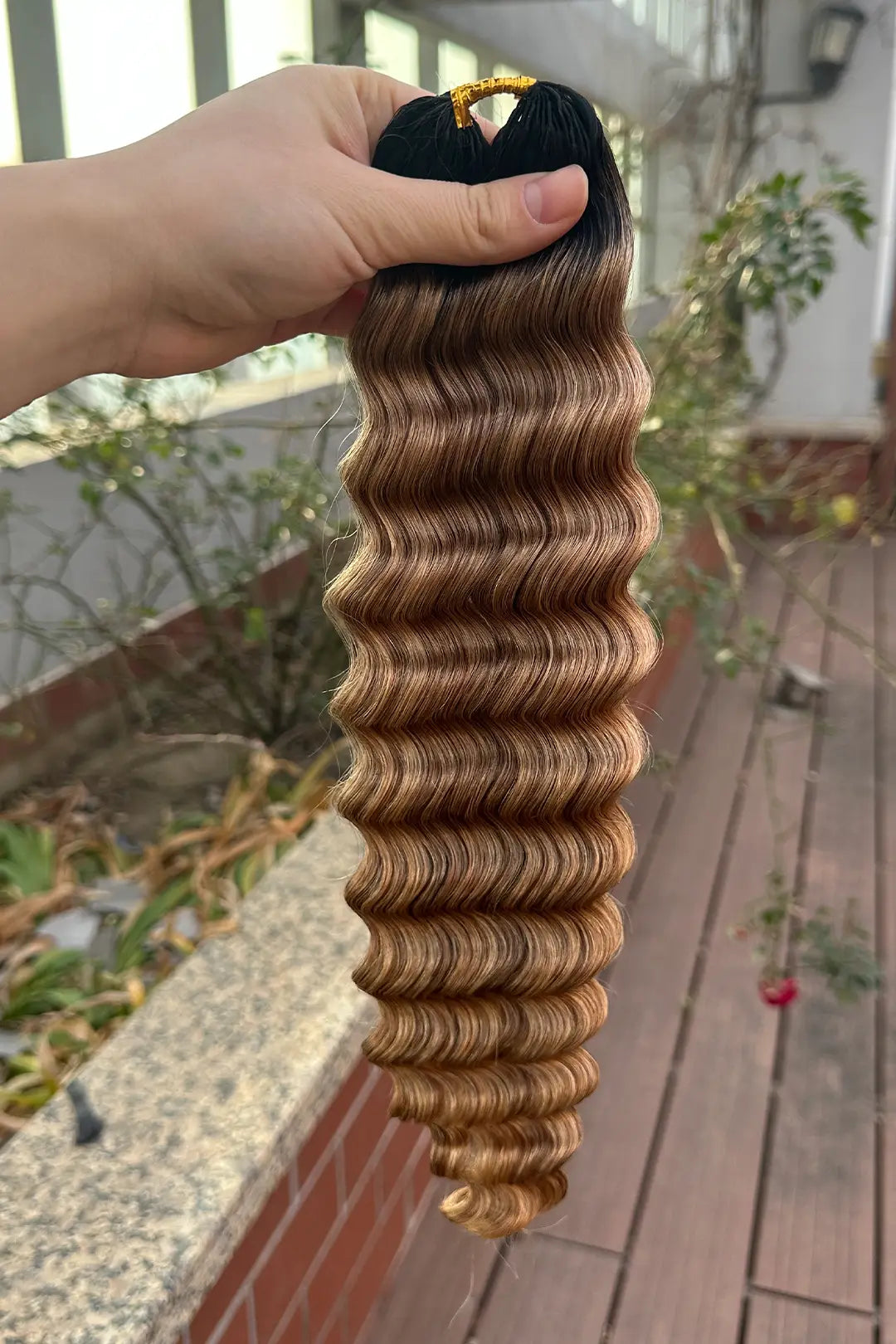 Outdoor picture of T1B/27 honey blonde deep wave feather crochet human hair